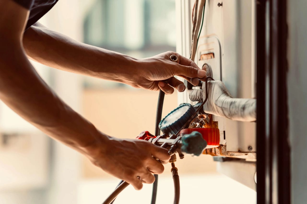 An air conditioning technician connecting refrigeration lines during a split system installation