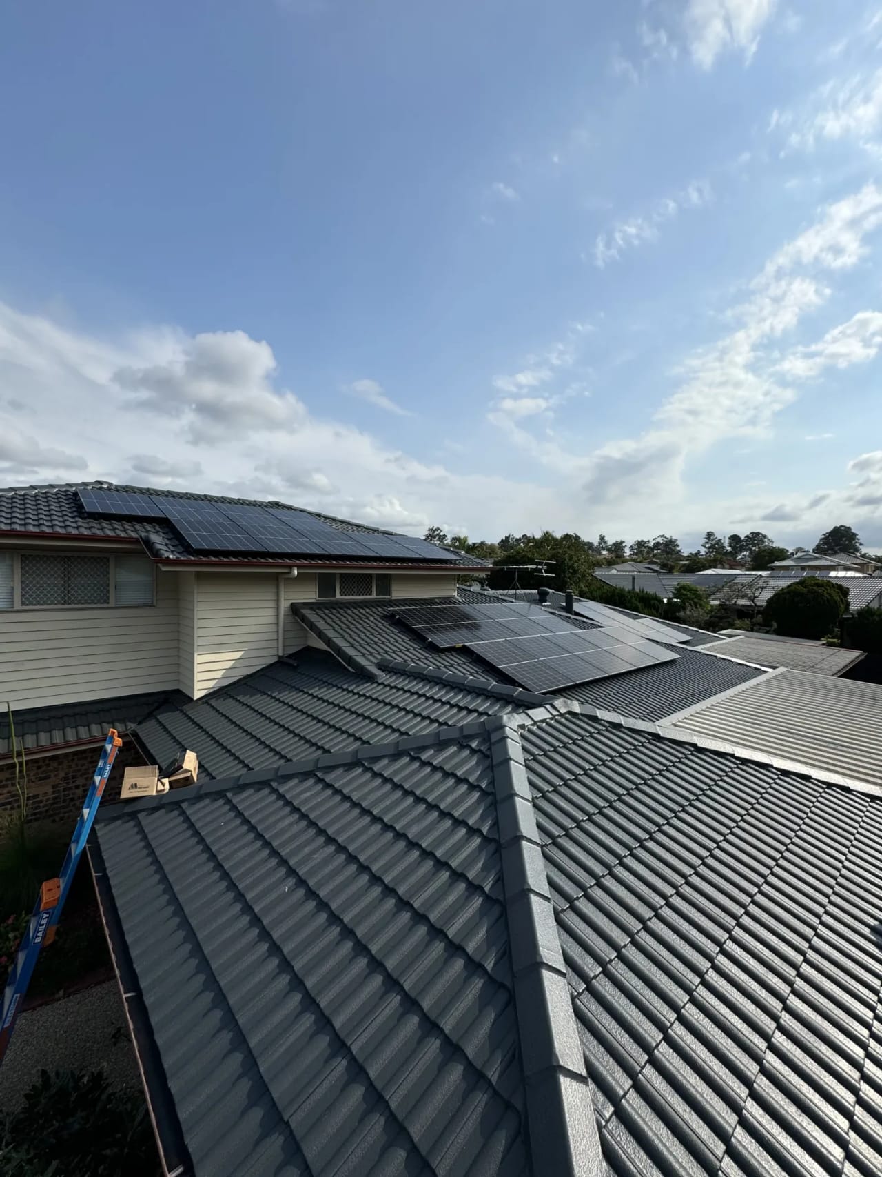 Solar panels on the tiled roof of a two-storey Queensland home